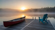 © PhotoArtHub - Image shows a red canoe and blue chair on a wooden dock by calm lake at sunrise. Represents peace, quietness, and an idyllic escape, ideal for nature themes