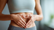 © Denis Yevtekhov - Fitness heart hands woman in gym with belly, gut health and inspiration for body goals, sport stomach athlete, weight loss digestion support in wellness routine, defocused background, with copy