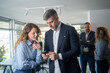 © Nenad - Colleagues man and woman chatting during conference break at workplace