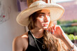© FATIR29 - A young woman wearing a straw hat watches the city from the window. the concept of travel and sightseeing