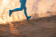 © Igor Yaruta - The legs of a fit jogging woman in blurred motion against sea background. Summer sports and vacation concept
