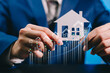 © JK_kyoto - Businessman holding house model with rising graph, real estate investment growth, property market analysis, mortgage finance planning, housing price increase forecast, real estate business concept