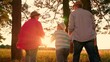 © Victoriia - Parents, son child walk hand in hand in park, sunset. Family walk in summer forest. Happy family, father mother, kid son, hiking in nature. Family picnic, outdoor recreation. People relaxing together