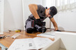 © zphoto83 - Man assembles furniture indoors using tools and following instructions on the floor