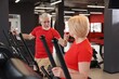 © New Africa - Senior couple training on elliptical machines in gym
