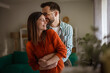 © Miljan Živković - Happy couple embracing, smiling, and sharing a loving moment at home