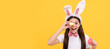 © Olena - surprised easter teen girl in bunny ears and bow tie hold painted eggs. Easter child horizontal poster. Web banner header of bunny kid, copy space.