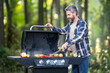 © Volodymyr - Man grilling steak on a backyard barbecue. Middle-aged male chef cooking gourmet meat outdoors on a grill terrace. Outdoor grilling. Barbecuing meat on a backyard grille. Grill barbeque bbq concept.