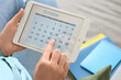 © Pixel-Shot - Woman using tablet computer with calendar at home, closeup