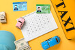 © Pixel-Shot - Calendar with taxi roof sign, money, driver's licenses and toy cars on yellow background