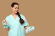 © Pixel-Shot - Portrait of female dentist with jaw model and set of dental tools on beige background