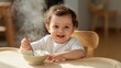 © LimeSky - A 2-year-old boy eats porridge at a children's table, showcasing independence. He's a cute toddler enjoying yogurt, smiling while seated in his high chair