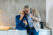 © Westend61 - Mature couple using cell phone together in kitchen at home
