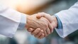 © e_zeynall1 - Two healthcare professionals shaking hands in a symbol of agreement and partnership, embodying trust, collaboration, and a shared dedication to patient care.