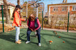 © _KUBE_ - Elderly Caucasian woman works with a personal trainer on outdoor equipment. Physical activity improves mobility, health, and long term recovery.