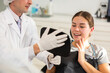 © JackF - During appointment, dentist demonstrates to patient result of cosmetic dental filling. Man dentist specialist holds mirror in front of girl patient and suggests evaluating effect of treatment.