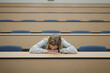 © christophe papke - Studentin schläft im Hörsaal – Müdigkeit, Lernstress und Erschöpfung im Studium