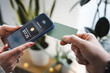 © Studio Marmellata - A person uses a smartphone to make a contactless payment with a card.