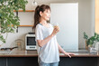 © buritora - Middle-aged Asian woman rehydrating and replenishing nutrients after training in the living room at home