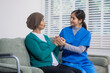 © Thitaporn - A young Asian nurse provides emotional support to an elderly female cancer patient at home, offering reassurance, compassionate care, medical consultation, and professional guidance during treatment