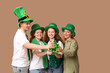 © Pixel-Shot - Group of people with beer on beige background. St. Patrick's Day celebration