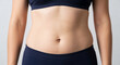 © Angavlan - Body acceptance displayed by woman's midsection, showing natural curves and healthy skin. Body acceptance concept focuses on self love and appreciation for individual physique.