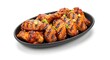 © Poindexter - Delicious grilled chicken wings with sesame seeds and green onions on a black plate, isolated on white. Perfect for a savory meal or appetizer.