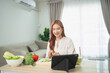 © WMSTUDIO - Young woman cooking healthy meal in bright kitchen with tablet, vegetables, and cheerful atmosphere, enjoying time in modern home setting
