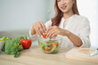 © WMSTUDIO - Woman Preparing Fresh Salad with Colorful Vegetables in Modern Kitchen Environment, Healthy Eating and Cooking Concept