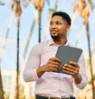 © Lumos sp - Portrait of a young  businessman wman using a tablet computer  in a city park, surrounded by modern corporate office buildings architecture