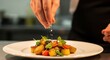 © Farhan - Chef Garnishing a Plated Salad with Fresh Herbs in Professional Restaurant