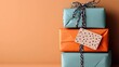 © Mpi - Stack of Three Wrapped Birthday Presents in Teal and Orange with Black and White Ribbon and Gift Tag on a Warm Peach Background Celebrating a Special Occasion