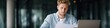 © Andrii Zastrozhnov - Young caucasian male analyzing documents in modern office setting