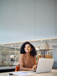 © insta_photos - Happy young African American business woman employee using laptop at work in office. Professional busy businesswoman executive, company worker or manager looking away working at computer. Vertical
