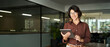 © insta_photos - Smiling young Hispanic professional business woman wearing glasses using tablet standing in office. Happy businesswoman company manager, female entrepreneur or employee looking at camera. Portrait.