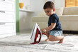 © New Africa - Child safety at home. Little boy playing with iron indoors, space for text