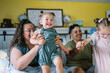 © Serena Burroughs/Stocksy - happy lgbtq family on big bed playing together