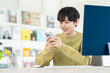 © pain au chocolat - オフィスでスマホを使う若い男性のデザイナー