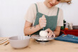 © Tania Cervian/Stocksy - Happy artisan making ceramic using clay at table