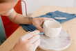 © Tania Cervian/Stocksy - Crop craftswoman drawing line on bowl
