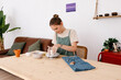 © Tania Cervian/Stocksy - Focused woman ceramist molding clay pot on workbench