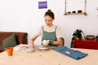 © Tania Cervian/Stocksy - Female ceramist modeling clay at table in house