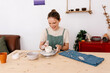© Tania Cervian/Stocksy - Happy artisan creating clay pot in art studio