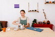 © Tania Cervian/Stocksy - Smiling woman crafting ceramic bowl wooden workbench