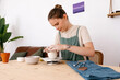 © Tania Cervian/Stocksy - Focused female artisan working on project on workbench