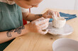 © Tania Cervian/Stocksy - Crop craftswoman decorating ceramic bowl