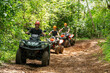 © Leonardo Borges/Stocksy - Group riding ATVs in the forest