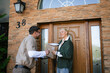 © DZ FILM/Stocksy - The postman delivers the parcel to the customer