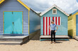 © Shava Cueva/Stocksy - Man enjoying sunshine by vintage beach huts in in Brighton Beach