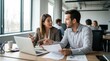 © designerjahanara - Business colleagues discussing documents and data on laptop in modern office